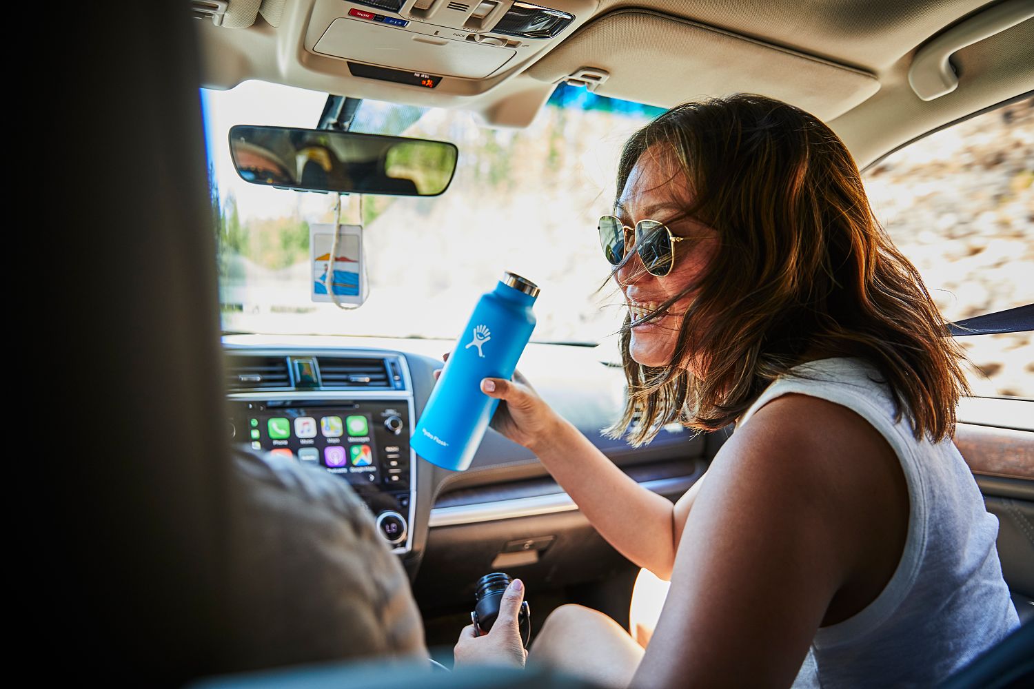Woman in car holding Hydro Flask® 21 oz Wide Mouth Insulated Tumbler in pacific