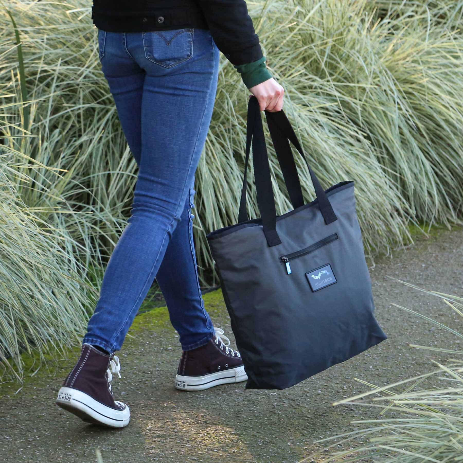 Person walking and holding gray Recycled Water Resistant Tote Bag 18x15