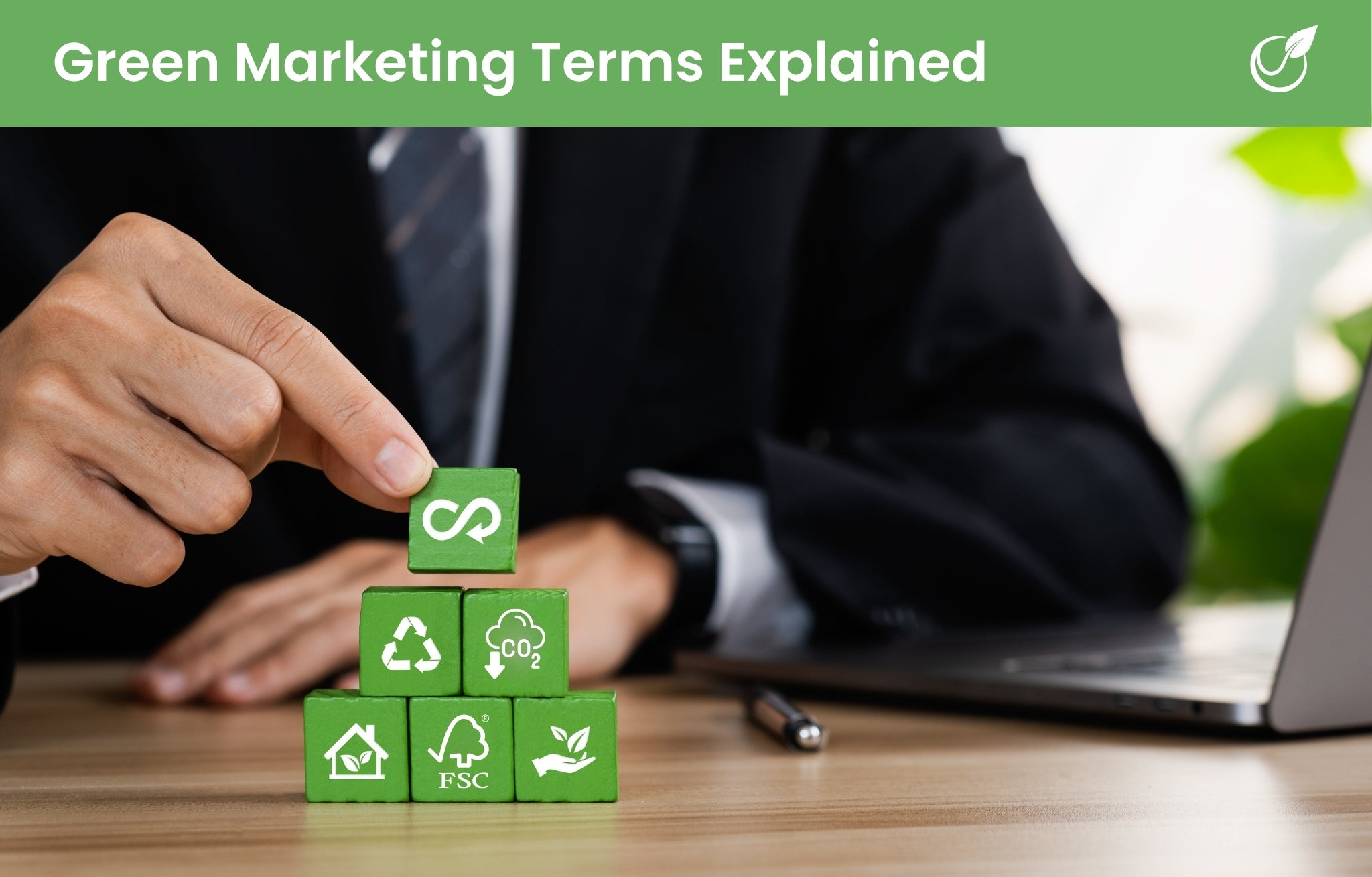 Text reading "green marketing terms explained" with a person playing with green icon blocks