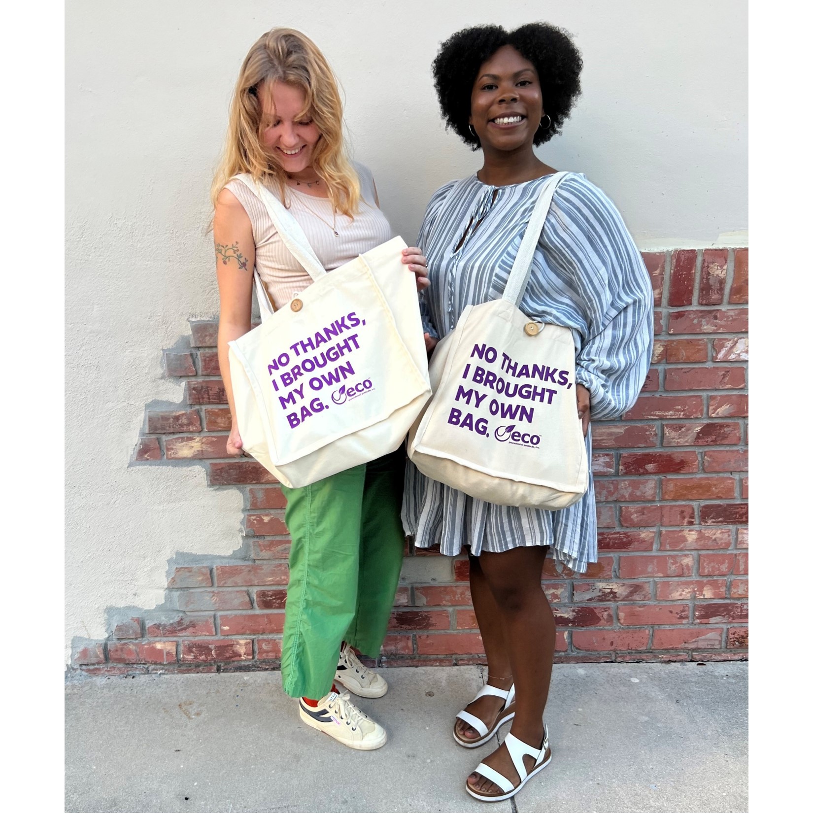 two women wearing customized tote bags 